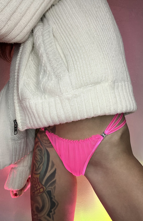 Handmade lingerie panties with a gathered front and 3 elastic bands around the hips. The panties are held in place by a butt plug. There is a small opening fastener on the left and right of the fabric triangle at the front.