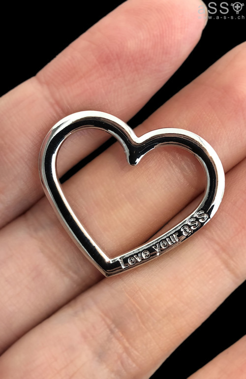 Lencería hecha a mano con tirantes elásticos de color metálico. La lencería es de una sola pieza y llega hasta el cuello. La parte delantera del cuello tiene un pequeño corazón de metal grabado con la inscripción «Love your aSS». En la parte inferior, la lencería se sujeta con un plug anal. Todas las correas son ajustables.